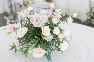 Beautiful table setting with crockery and flowers for a party, wedding reception or other festive event. Glassware and cutlery for catered event dinner.