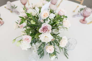 Beautiful table setting with crockery and flowers for a party, wedding reception or other festive event. Glassware and cutlery for catered event dinner.