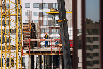 Workers engineers working at construction site and cranes on background of new building skyscrapers. Industrial landscape with building steel and concrete. worker engineer looking at development