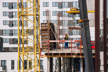 Workers engineers working at construction site and cranes at new building skyscrapers. Industrial landscape with building steel and concrete. worker engineer looking at development