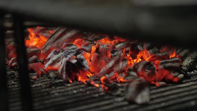 Typical Argentinian barbecue or asado. Burning wood in the grill and red hot coals
