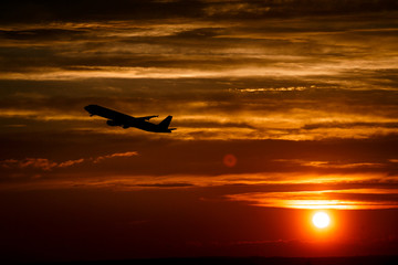 Airplane at sunset sky in the air with space for text. Silhouette of a big passenger  aircraft in sun light. transportation concept. plane flying in the dramatic sky. amazing atmospheric image