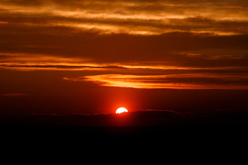 amazing sun at dusk clouds. sunset image. beautiful red cloudy sunset  in orange sky, dramatic view. fascinating wallpaper. beautiful nature moments, breathtaking scenery. pure beauty