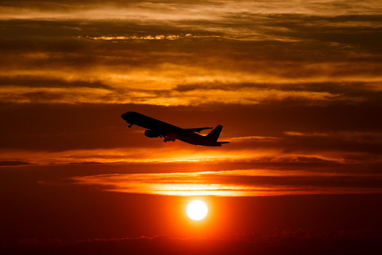 Airplane at sunset sky in the air with space for text. Silhouette of a big passenger  aircraft in sun light. transportation concept. plane flying in the dramatic sky. amazing atmospheric image