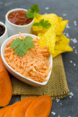 carrot salad with chili and soy sauce on the black table.