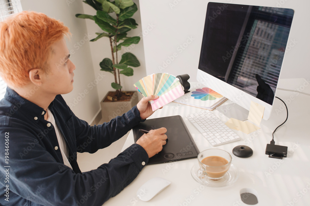 Aufkleber smiling photo editor working on computer at desk with camera and graphics tablet