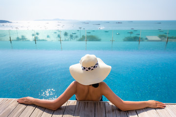 Fototapeta na wymiar Portait of asian woman relaxing in swimming pool with sunbathe