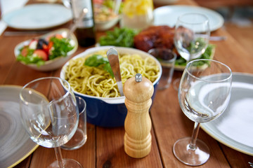food, seasoning and eating concept - pepper mill or salt grinder on served wooden table