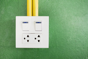 Plug and socket on wall as green background