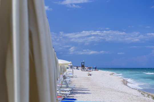 beach of marotta in the italian region of marche during summer with parasols and clouds