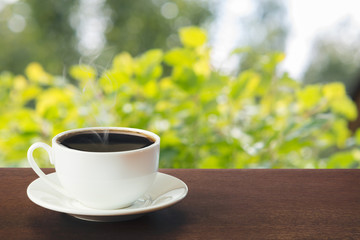 Hot cup of black coffee in a sunny day on tabletop. Summer. Outdoors.