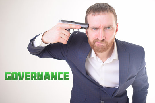 The businessman holds a gun in his hand and shows the inscription:GOVERNANCE