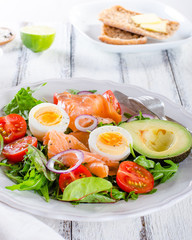 Smoked salmon salad with greens, tomatoes, eggs and avocado