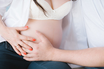 A pregnant woman gently caresses her belly