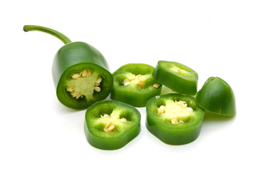sliced green chilies on white background
