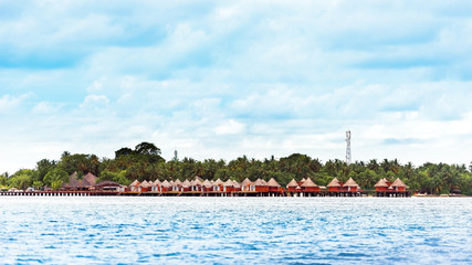 Fototapeta na wymiar Water villas on tropical caribbean island, Maldives. Copy space for text