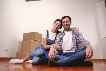 Portrait of a beautiful smiling couple of lovers just arrived in the new house to start a new journey together. Concept of: love, family, home.