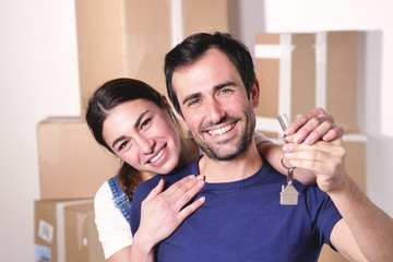 Portrait of a beautiful smiling couple of lovers just arrived in the new house to start a new journey together. Concept of: love, family, home.