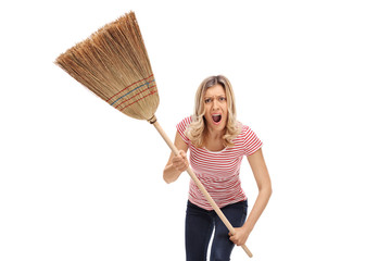 Angry young woman with a broom