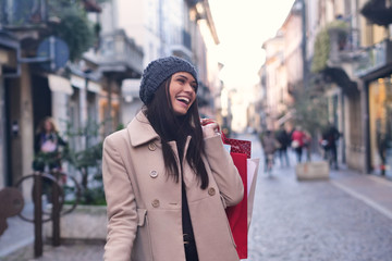 A beautiful smiling young girl, while she is having a shopping day. Concept of: shopping, entertainment, friendship, love and leisure.
