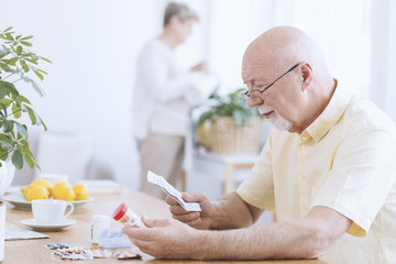 Man reading his medicines' prescription