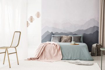 Cozy bed by landscape wallpaper