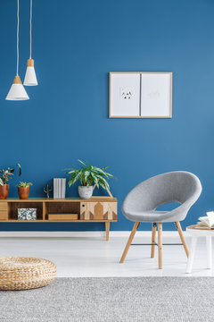 Grey armchair in blue interior