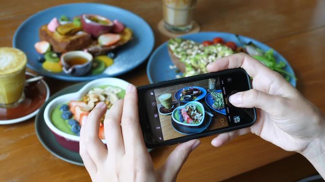 Breakfast Trends. Female Blogger Taking Photos Of Food With Cellphone In Cafe