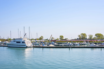 Daylight view to a port with parked yachts and trees