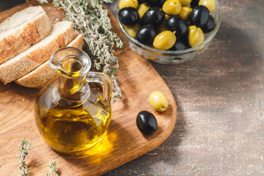 Glass bottle of olive oil with olives