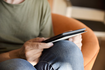 Fototapeta premium young man using a tablet sitting in a couch