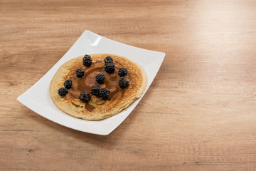 Pancakes with black currant and chocolate sauce. - 198473635