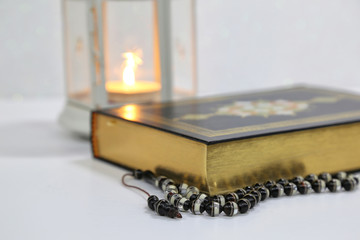 Islamic Holy Book Quran under soft light on White Background. Ramadan concept . The Koran with rosary beads