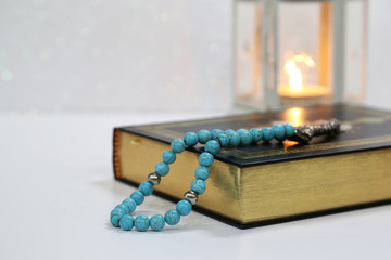 Islamic Holy Book Quran under soft light on White Background. Ramadan concept . The Koran with rosary beads