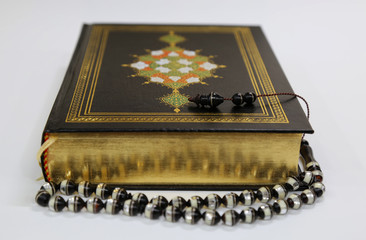 Islamic Holy Book Quran under soft light on White Background. Ramadan concept . The Koran with rosary beads