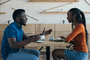 side view of african american couple having conversation during date in coffee shop - Powered by Adobe