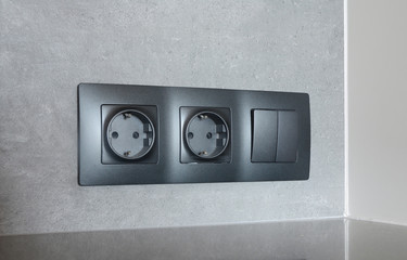 Black outlet plug on the modern kitchen wall. Socket and european power.