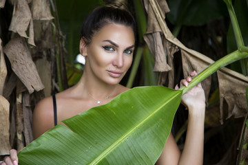 fashion photo of brunette in the jungle with bright makeup , posing outdoor