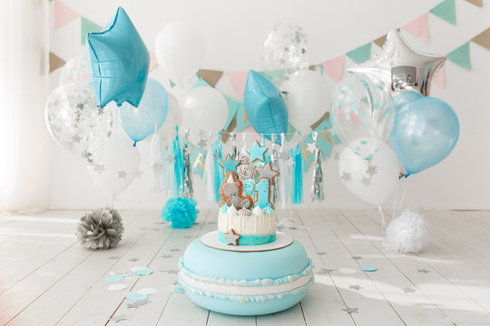 First birthday decorated room with blue cake standing on big macaroon