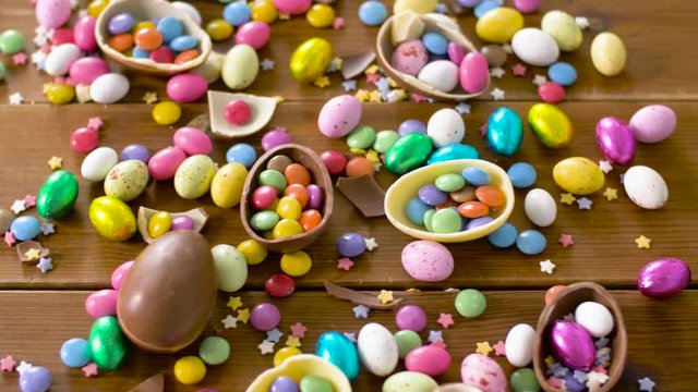 easter, junk-food, confectionery and unhealthy eating concept - chocolate eggs and drop candies on table
