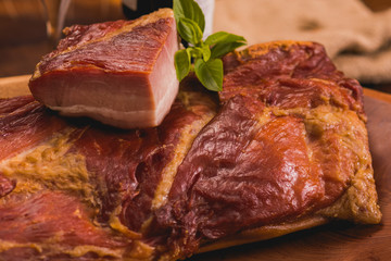 bacon in piece on rustic table, in the background red wine