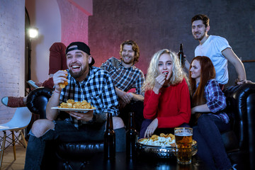 Friends watching a football match and drinking beer.