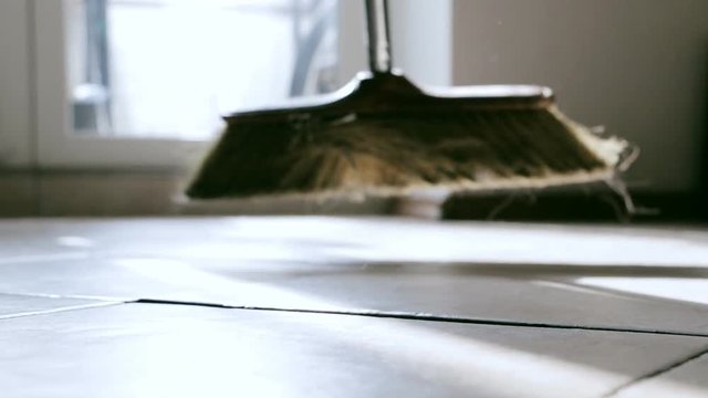 Sweeping floor with swab. Closeup. Selective focus. Concept of manual cleanup, housework and household.