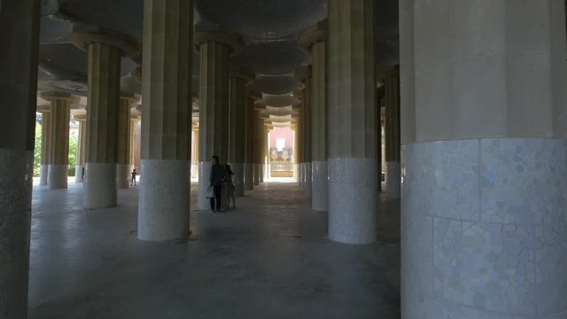 Visiting the building with columns in Park Guell, Barcelona
