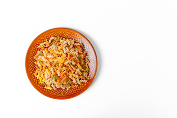 Food and drink concept - uncooked pasta on palte isolated on white background. Top view.