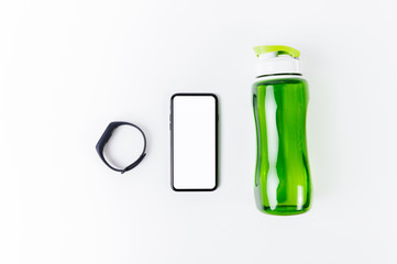 Fitness concept, Fitness tracker, bracelet with smartphone with blank white screen and bottle of...