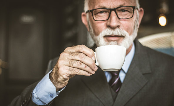 Senior businessman drinking coffee. Close up image.
