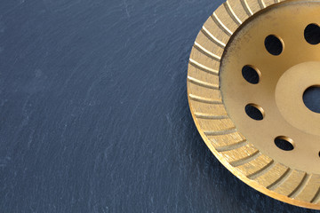 Part of the diamond grinding wheel on a gray granite background.