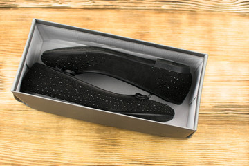 black suede female ballet flats on a wooden background © Hanna