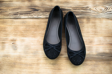 black suede female ballet flats on a wooden background © Hanna